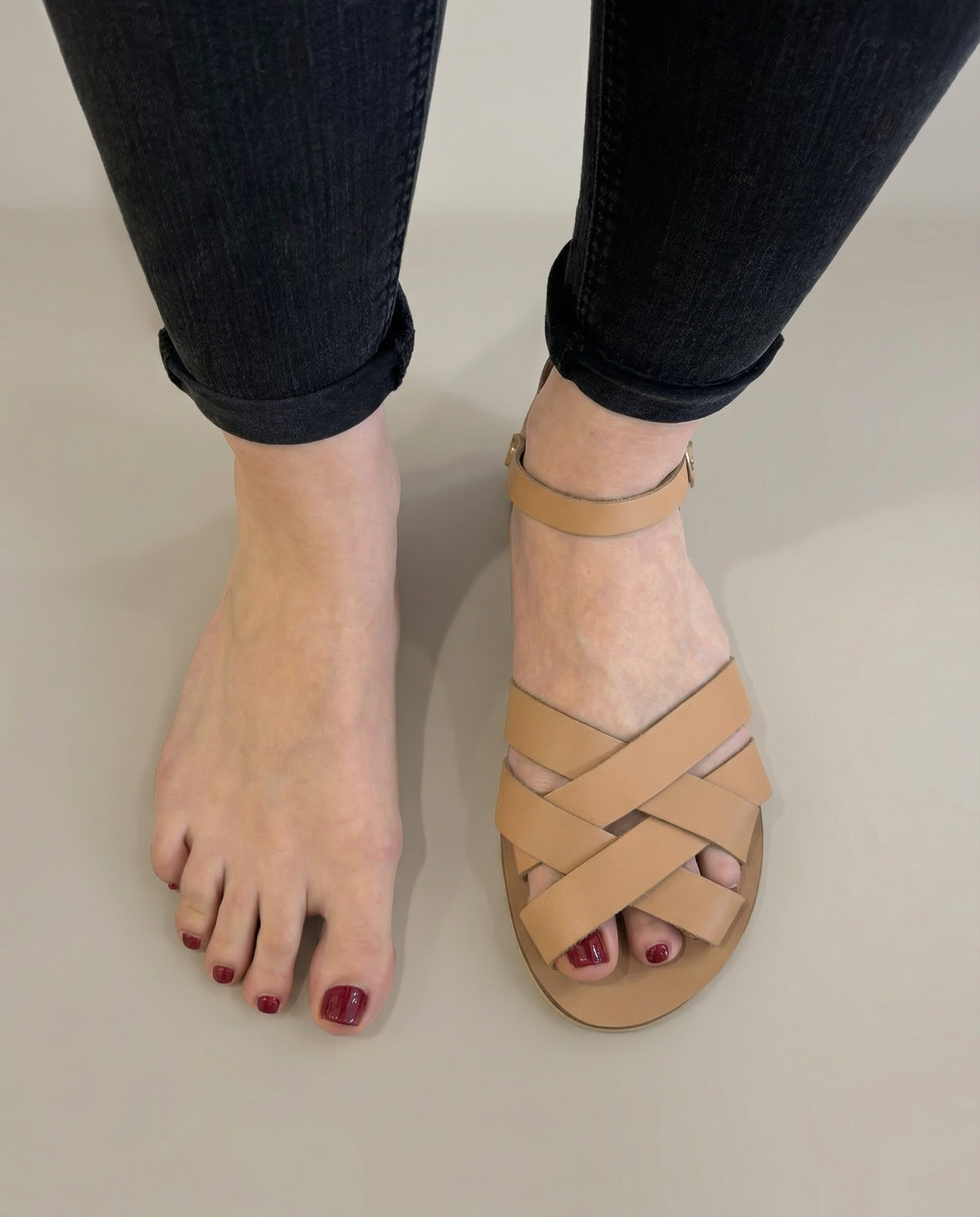 demeter sandały na szeroką stopę, jasny beż, jedna stopa w sandałach, druga bosa, widok z góry
